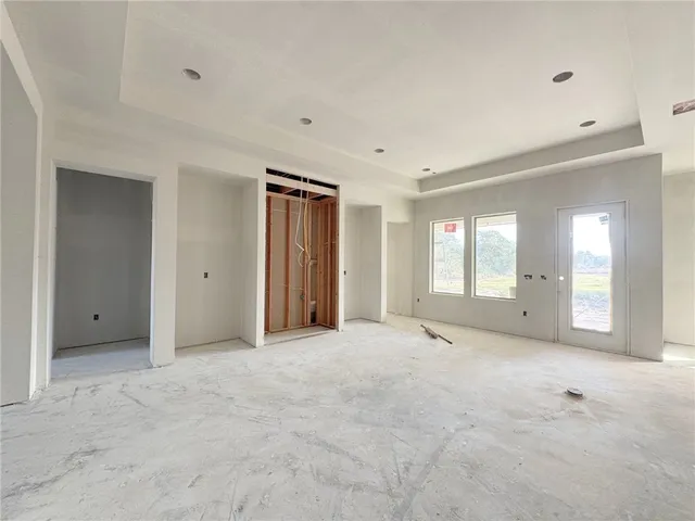 a view of an empty room with window and bathroom