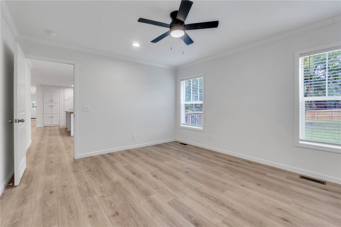 108 Old River Road Iva, SC 29655 - Photo 13 of 31 A well-lit interior space features sleek wood flooring and a modern ceiling fan.