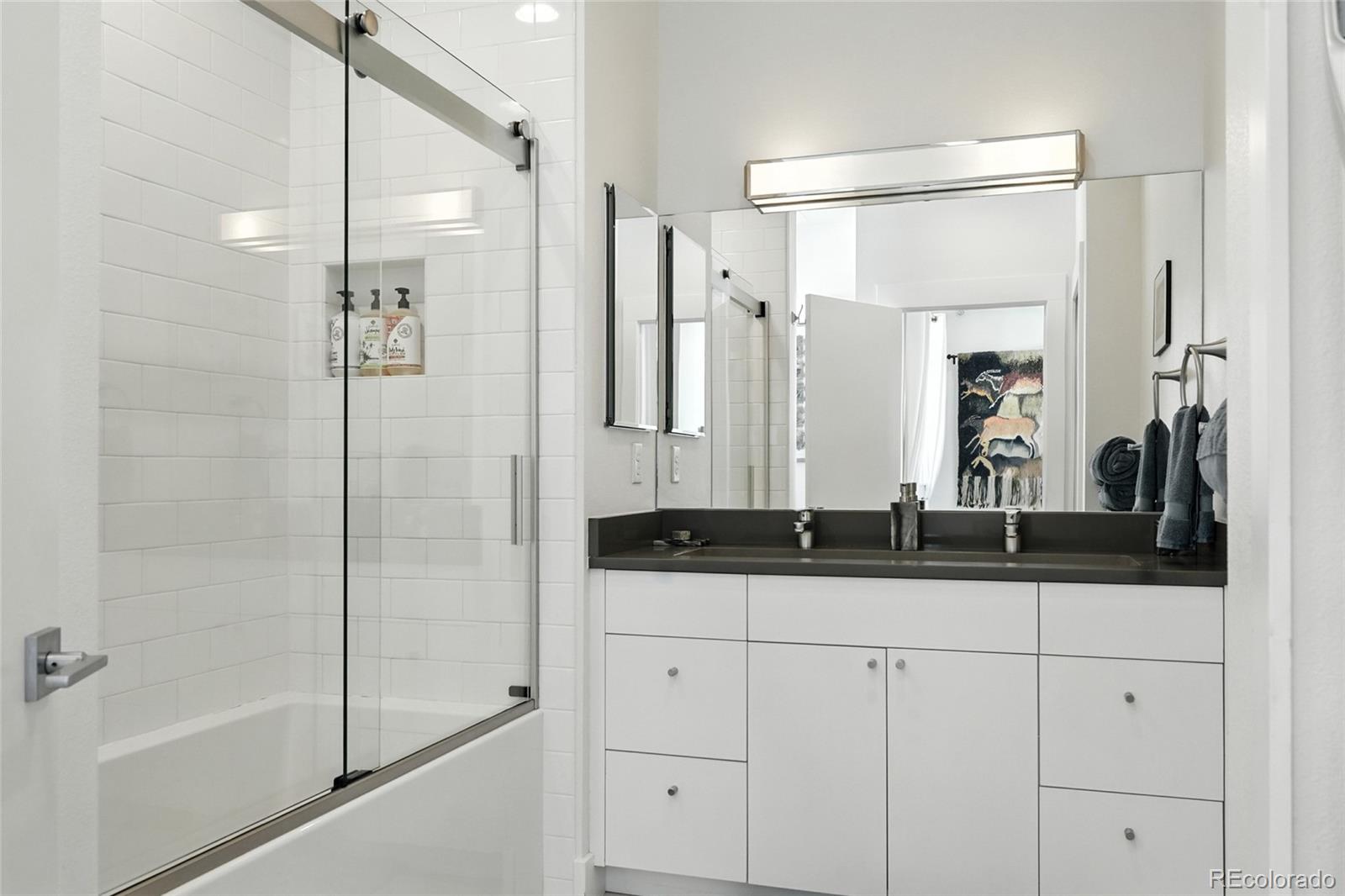 2530 28th Street, Unit 118 Boulder, CO 80301 - Photo 17 of 30 a bathroom with a granite countertop sink mirror and shower
