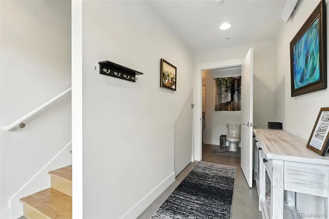 a view of a hallway with bathroom and wooden floor