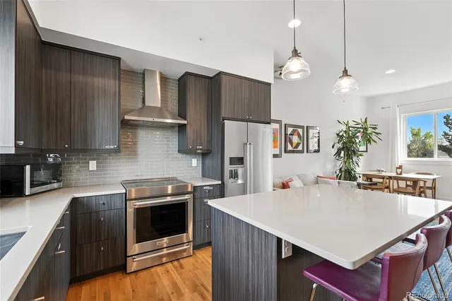 a kitchen with stainless steel appliances a stove a refrigerator a sink and a refrigerator