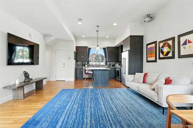 a living room with furniture kitchen view and a flat screen tv