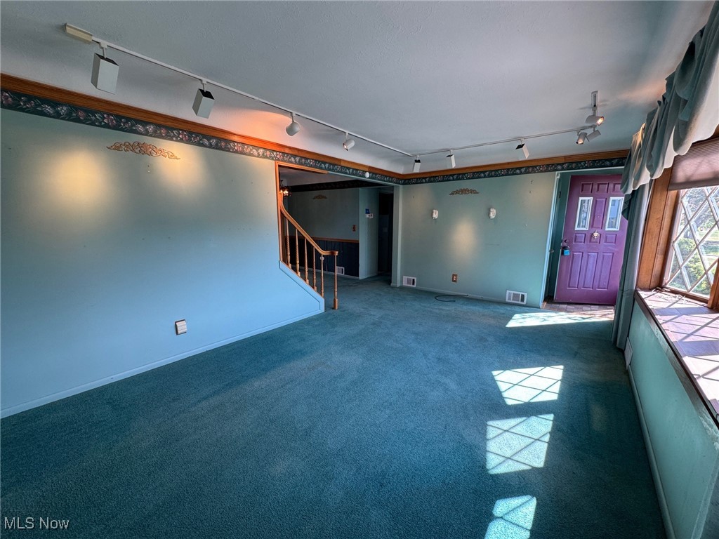 725 Pendley Road Willowick, OH 44095 - Photo 30 of 36 Living room featuring track lighting, stairway, and front entryr