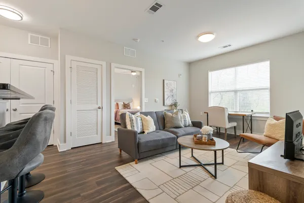 a living room with furniture a flat screen tv and a window