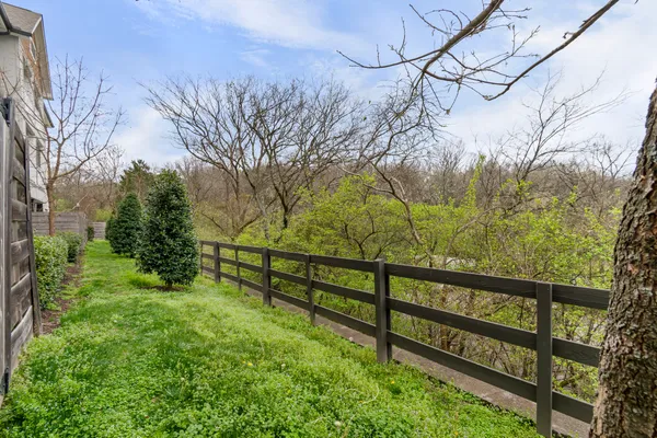 a view of a yard with wooden fence