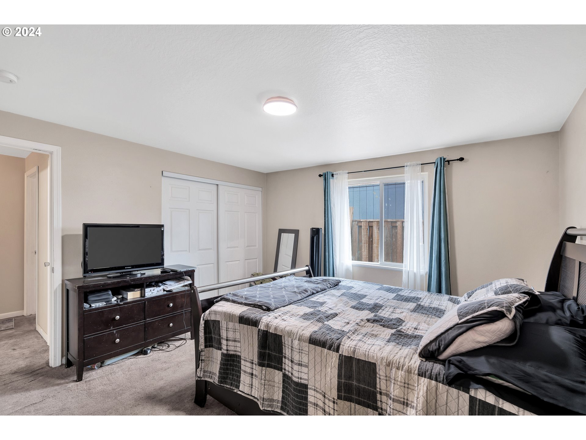 325 Cosmo Street Lafayette, OR 97127 - Photo 21 of 29 a bedroom with a bed and a flat screen tv