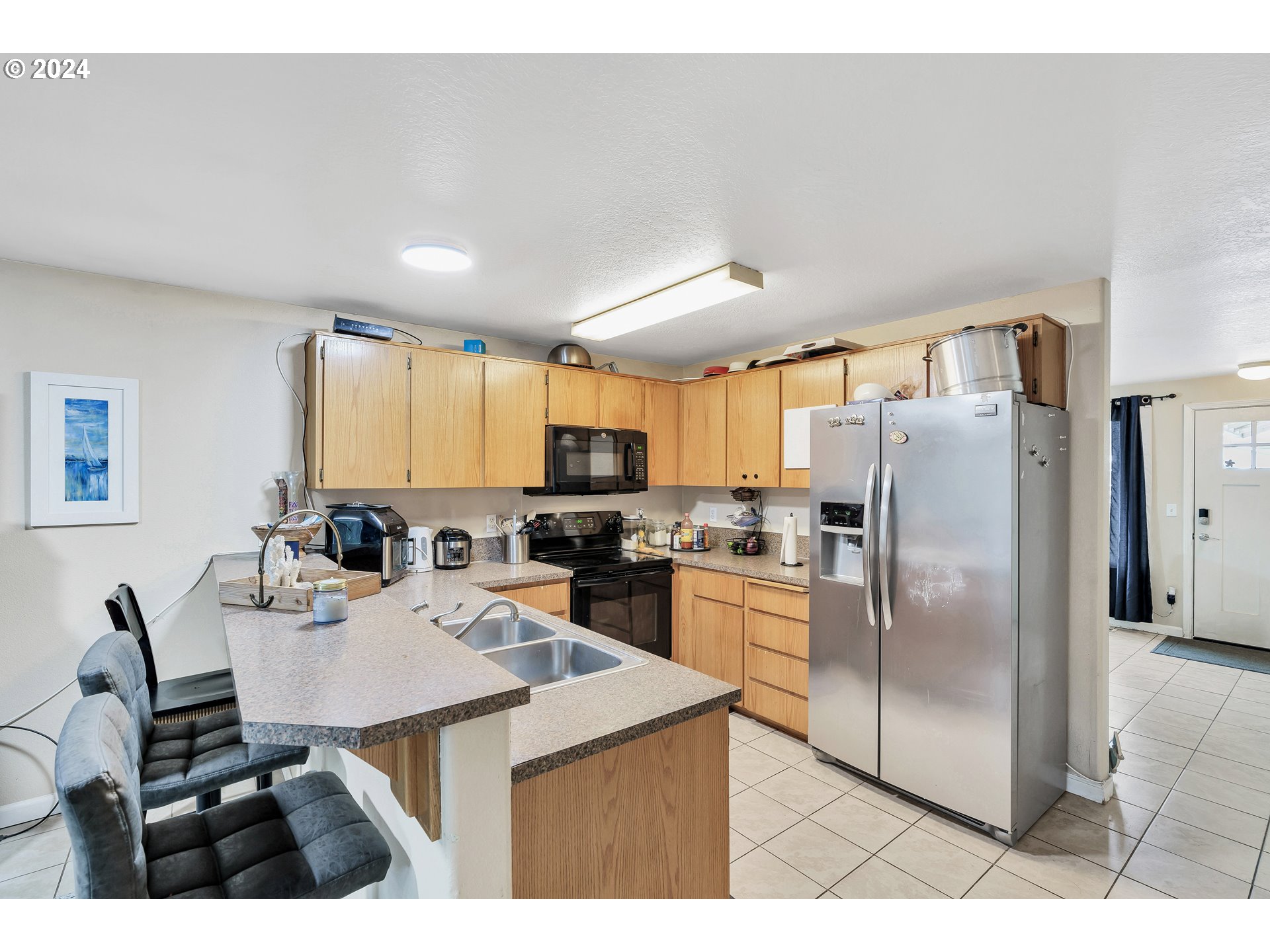 325 Cosmo Street Lafayette, OR 97127 - Photo 8 of 29 a kitchen with stainless steel appliances kitchen island granite countertop a refrigerator a stove a sink dishwasher with a dining table and chairs with wooden floor