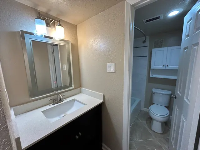 a bathroom with a sink a toilet and mirror