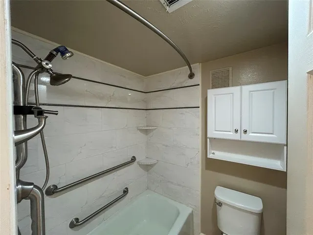a bathroom with a shower a toilet and sink