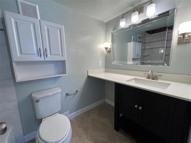 a bathroom with a toilet sink vanity and mirror