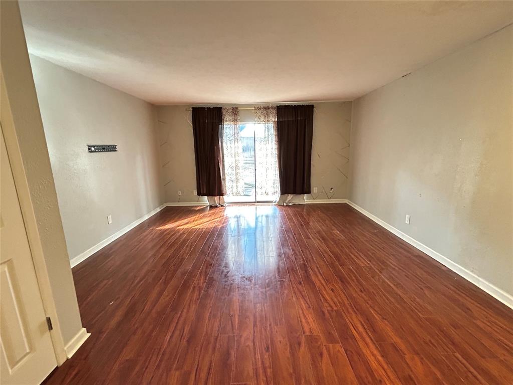 4535 North O'Connor Road, Unit 1216 Irving, TX 75062 - Photo 7 of 24 a view of an empty room with wooden floor and a window