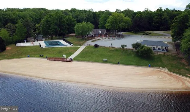 a view of backyard with swimming pool and seating space