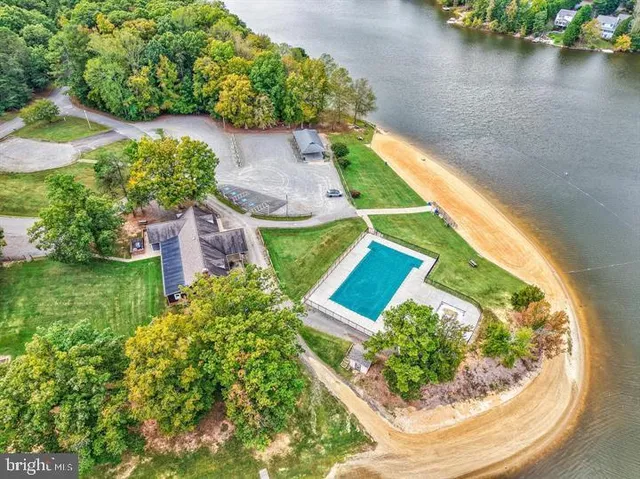 an aerial view of a house with a garden and lake view
