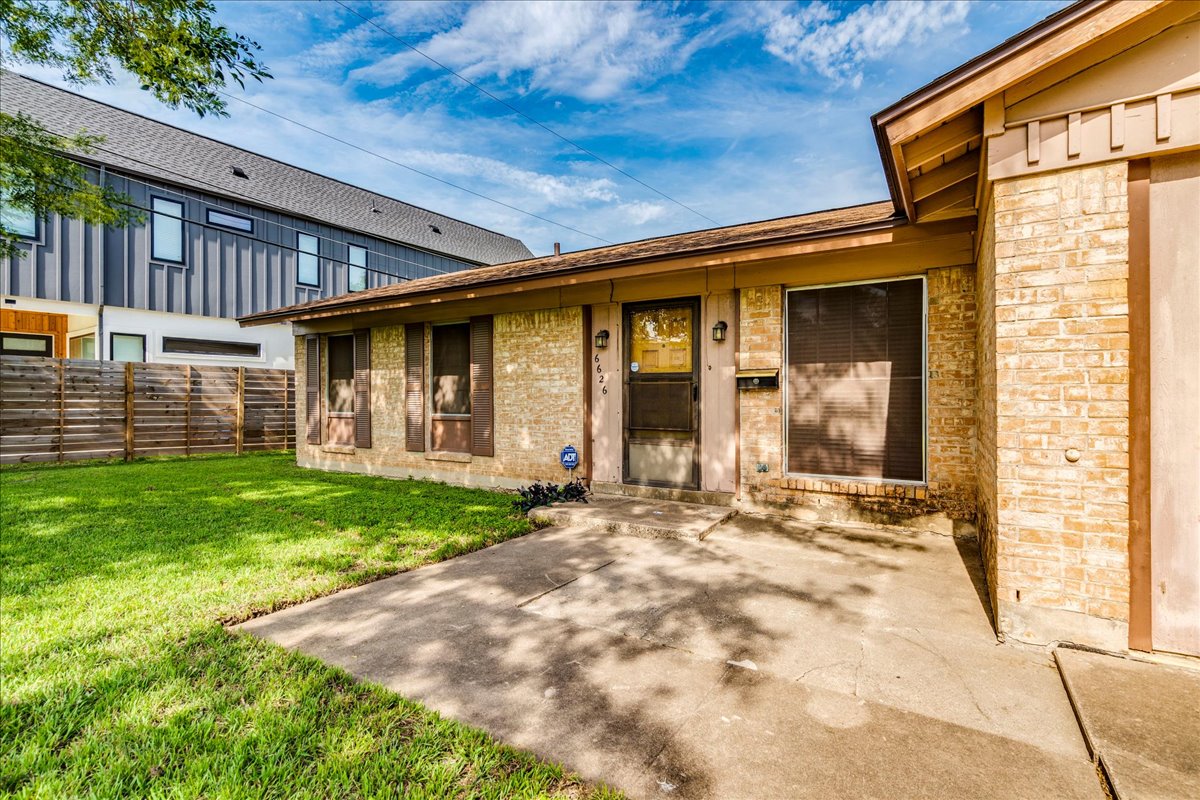 6626 Isabelle Drive Austin, TX 78752 - Photo 6 of 27 Brick exterior with a brown roof and a front yard
