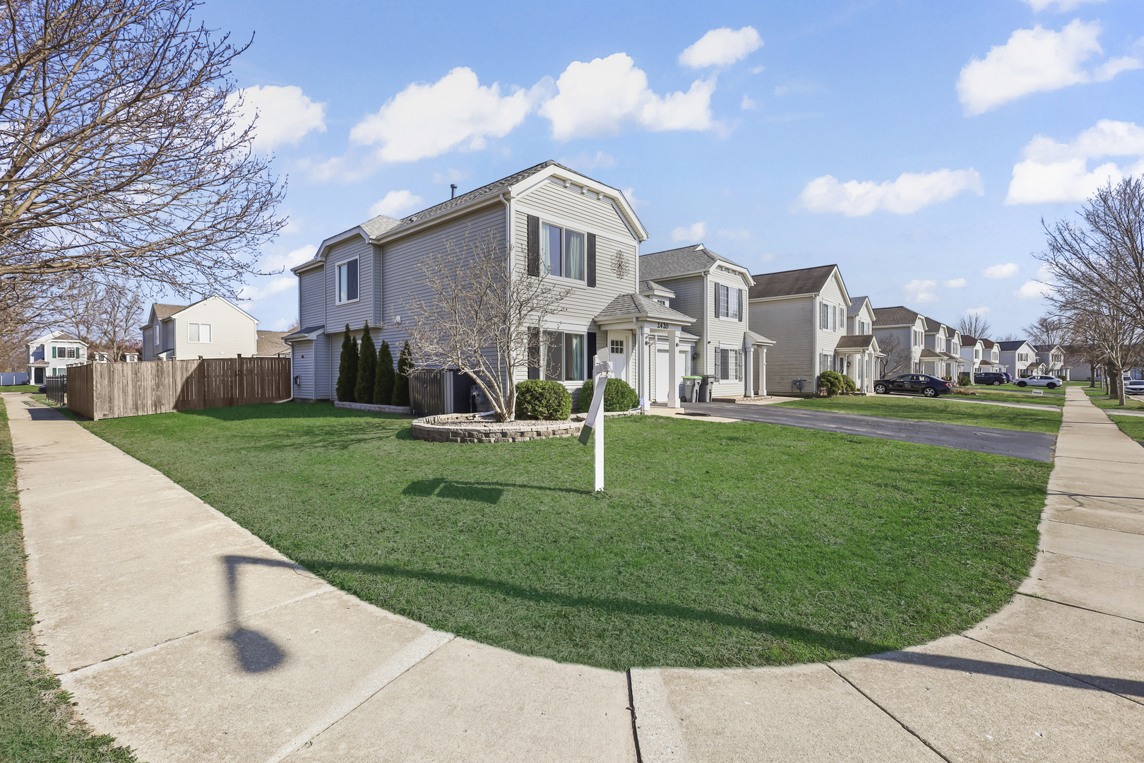 2420 Roxbury Lane Montgomery, IL 60538 - Photo 2 of 25 a view of a white house with a yard and plants