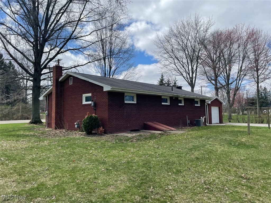 855 Georgetown Road Salem, OH 44460 - Photo 22 of 28 View of home's exterior with central AC, a chimney, brick siding, and a lawn