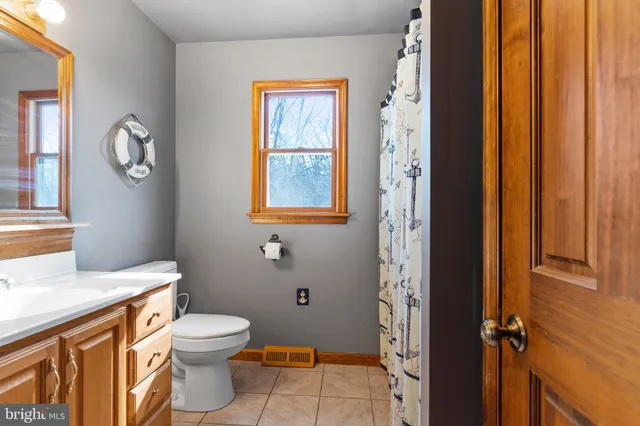 a bathroom with a toilet a sink and a window