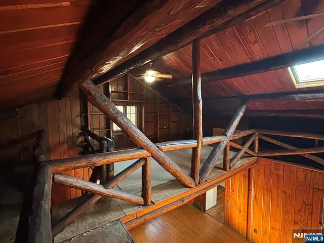 a view of an empty room with wooden floor and closet