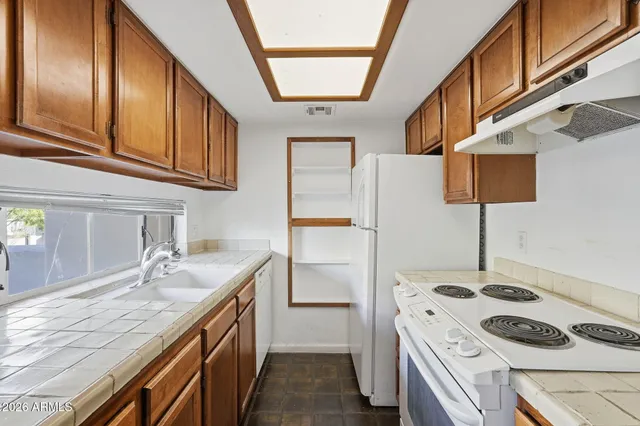 a kitchen with a sink a stove and cabinets