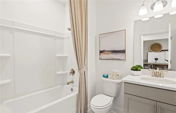 a bathroom with a toilet a sink a mirror a bathtub and vanity