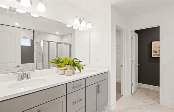 a bathroom with a granite countertop sink a potted plant and a mirror