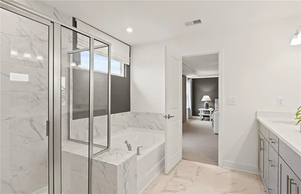 a spacious bathroom with a tub shower and bedroom