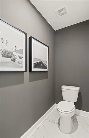 a white toilet sitting next to a bathroom sink