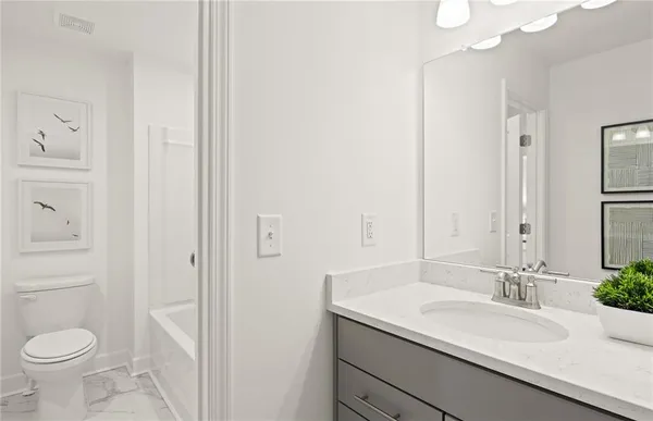 a bathroom with a granite countertop sink toilet and a mirror