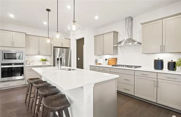 a large kitchen with cabinets chairs and stainless steel appliances