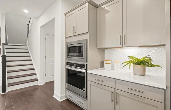 a kitchen with white cabinets and appliances