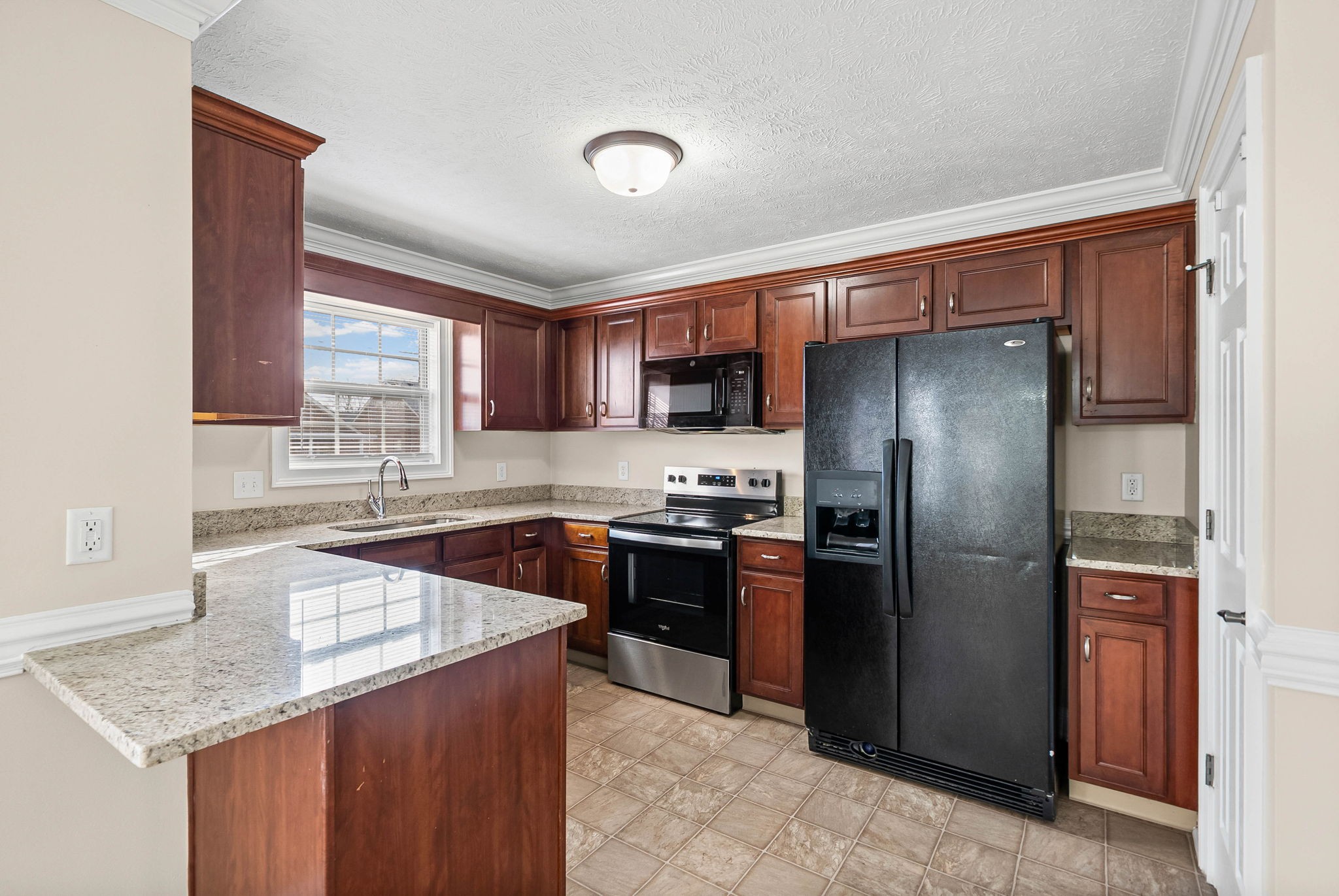 135 Excell Road, Unit 102 Clarksville, TN 37043 - Photo 9 of 24 a kitchen with stainless steel appliances granite countertop a refrigerator a sink a stove a microwave and island