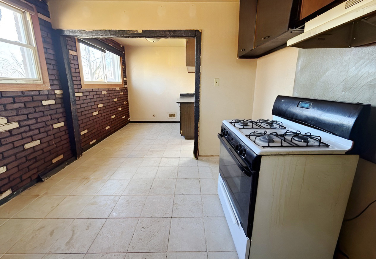 249 Eddy Street Chicago Heights, IL 60411 - Photo 4 of 10 a kitchen with granite countertop a stove a sink a refrigerator and window