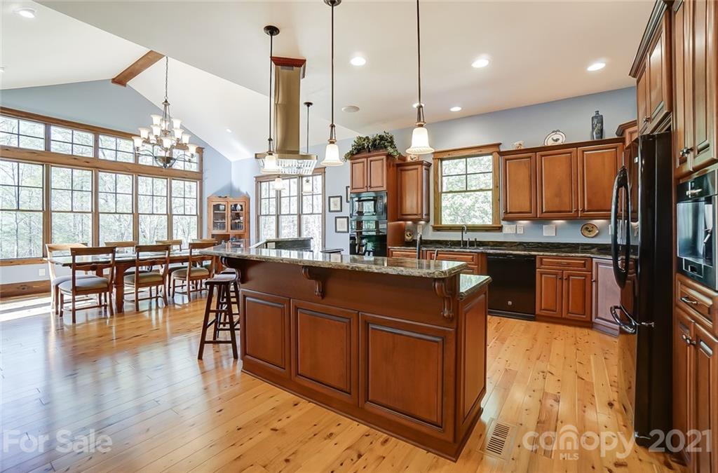215 Eagle Cove Drive Cherryville, NC 28021 - Photo 9 of 48 a kitchen with stainless steel appliances granite countertop a table chairs and a wooden floor