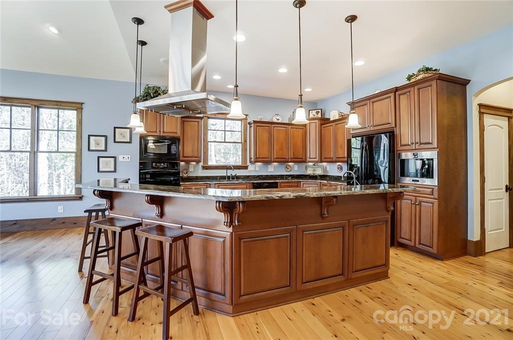 215 Eagle Cove Drive Cherryville, NC 28021 - Photo 10 of 48 a kitchen with stainless steel appliances kitchen island granite countertop a stove a sink and a refrigerator