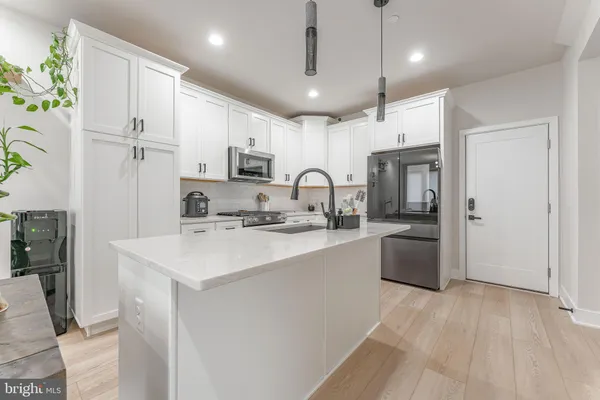 a kitchen with white cabinets and appliances