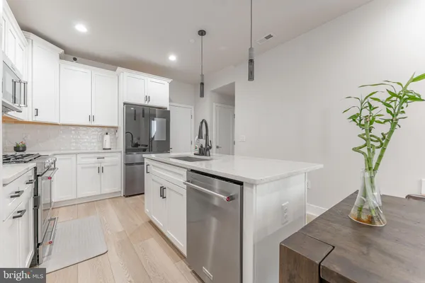 a kitchen with stainless steel appliances granite countertop a sink stove and refrigerator