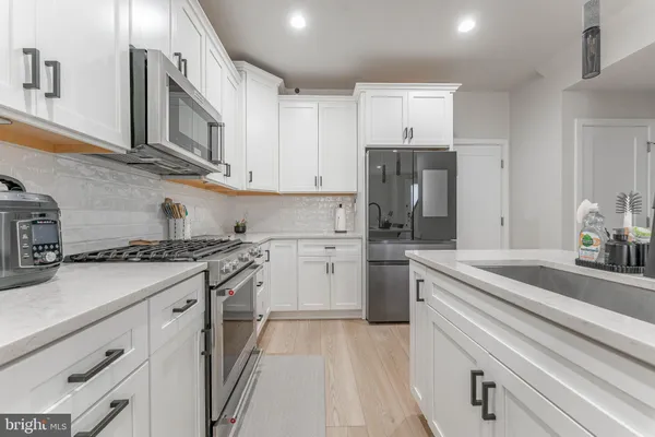 a kitchen with kitchen island white cabinets and white appliances