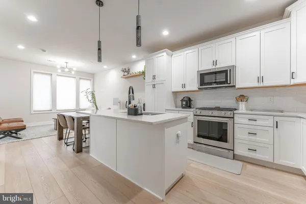a kitchen with sink stove and refrigerator