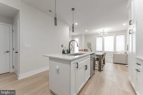 a kitchen with cabinets stainless steel appliances and wooden floor