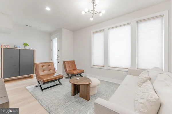 a living room with furniture and a dining table with wooden floor