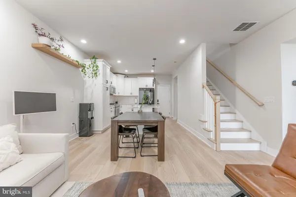 a living room with furniture and a dining table with kitchen view