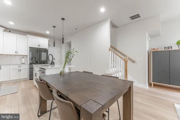 a kitchen with a table chairs refrigerator and microwave