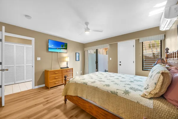 a bedroom with a bed dresser and wooden floor