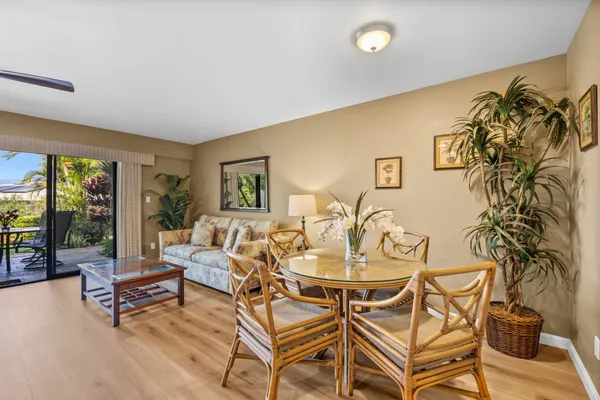 a living room with patio furniture and a potted plant