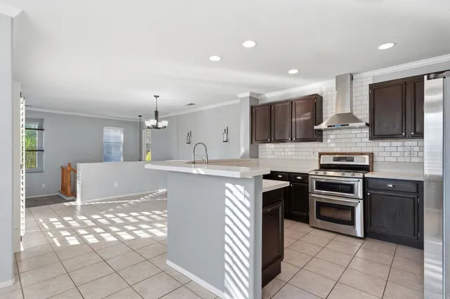 a kitchen with stainless steel appliances kitchen island granite countertop a refrigerator and a stove top oven