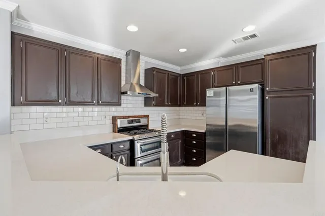 a kitchen with stainless steel appliances a refrigerator and a stove top oven