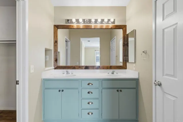 a bathroom with a granite countertop sink and a mirror