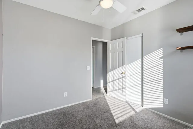 a view of a livingroom with a white wall and a ceiling fan