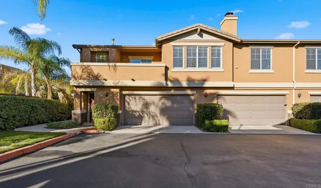 a front view of a house with a yard and potted plants