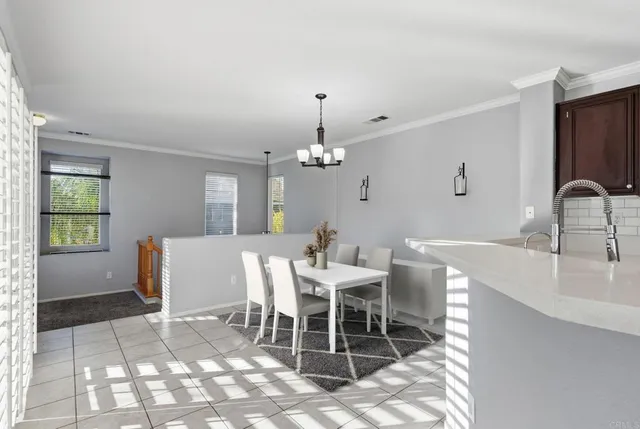 a dining room with wooden floor a chandelier a wooden table and chairs